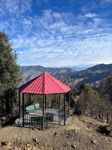 a gazebo with a bench on top of a mountain at Dhanolti Village Resort Dhanaulti in Dhanaulti