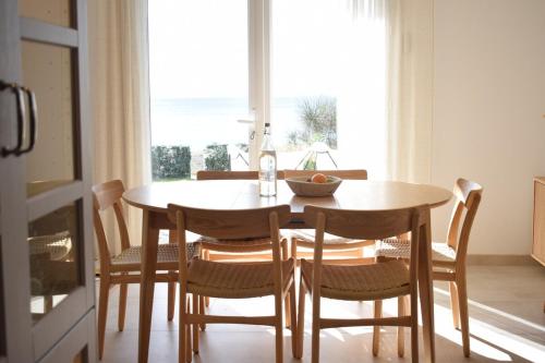 d'une table à manger et de chaises avec une grande fenêtre. dans l'établissement Maison Kermor, à Arzon