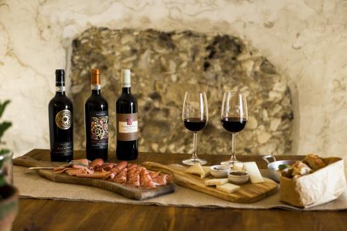 a table with two glasses of wine and meats at Relais Poggio Borgoni in San Casciano in Val di Pesa