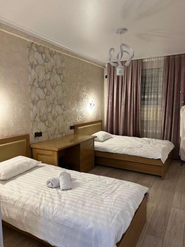 a bedroom with two beds and a chandelier at Достук in Karachiy
