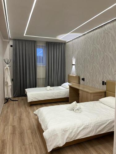 a hotel room with two beds and a window at Достук in Karachiy