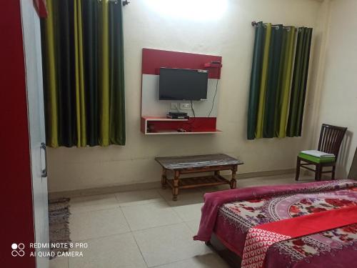 a room with a bed and a tv and curtains at Food Mania Hotel restaurant in Ner Chowk