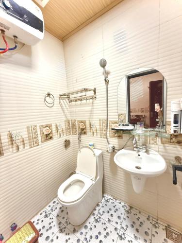 a bathroom with a toilet and a sink at Hotel Mountain View in Chinh Phú