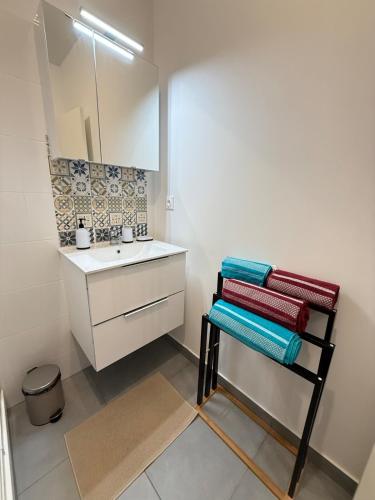 une salle de bain avec un lavabo, un miroir et des serviettes dans l'établissement Villa Amira Angely Vauban, à Nice