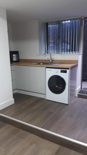 a kitchen with a washing machine and a sink at SHEFFIELD ARENA APPARTMENT s9 in Attercliffe