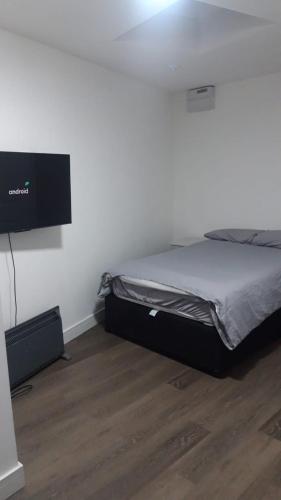 a bedroom with a bed and a tv on the wall at SHEFFIELD ARENA APPARTMENT s9 in Attercliffe