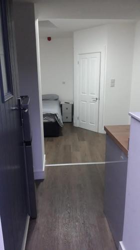 an empty room with a bed and a room with a kitchen at SHEFFIELD ARENA APPARTMENT s9 in Attercliffe