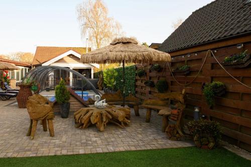 a patio with a table and chairs and an umbrella at Amazing 14 Berth Villa With Private Pool At Pentney Lakes In Norfolk Ref 34079A in Kings Lynn