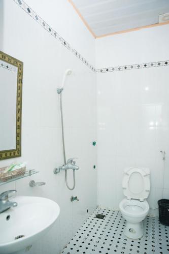 a white bathroom with a sink and a toilet at Khách Sạn Mai Hà Sầm Sơn in Sầm Sơn