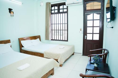 a room with two beds and a window at Khách Sạn Mai Hà Sầm Sơn in Sầm Sơn