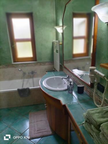 a bathroom with a sink and a mirror and a tub at Casale del sole in Palestrina