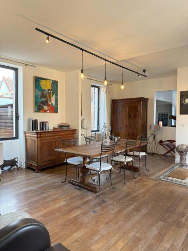 un salon avec une table et des chaises en bois dans l'établissement TM3L Family home, à Meillant