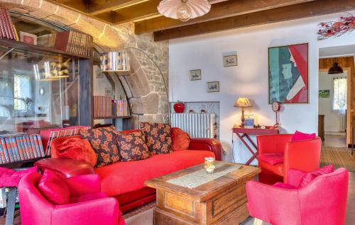 un salon avec un canapé rouge et deux chaises dans l'établissement 5 Bedroom Awesome Home In Villedieu-Les-Poêles, à Villedieu-les-Poêles