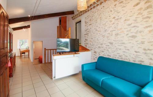 a living room with a blue couch and a tv at Gorgeous Home In Piegon With Sauna in Piégon