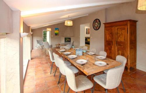 a dining room with a wooden table and white chairs at Gorgeous Home In Piegon With Sauna in Piégon