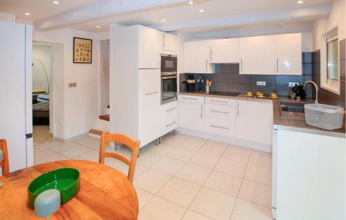 a kitchen with white cabinets and a wooden table at Gorgeous Home In Piegon With Sauna in Piégon