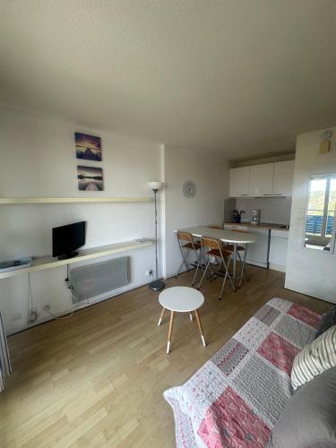 un salon avec une table et une cuisine dans l'établissement Bleu Marine Apts, à Lacanau-Océan