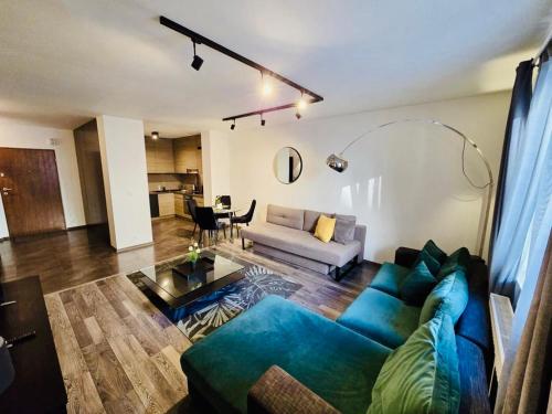 a living room with a blue couch and a table at Apartments Blue Angel, park free, children stay free in Krakow
