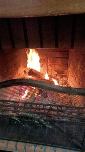 a brick oven with fire inside of it at Orion Guesthouse Telhado in Fundão