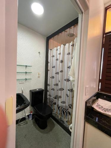 a bathroom with a black toilet and a sink at CONDOMÍNIO IMPERIAL, PRAIA DO FRANCÊS in Praia do Frances