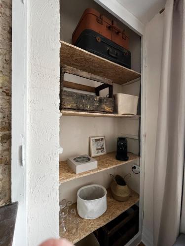 une étagère avec une valise et d'autres articles dans une pièce dans l'établissement Appartement Marine - Résidence La Porte Verte, à Boulogne-sur-Mer