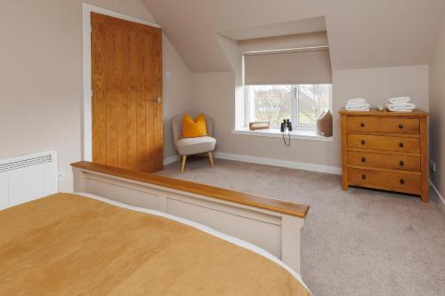 a bedroom with a bed and a dresser and a window at Croft@42 in Vatsker