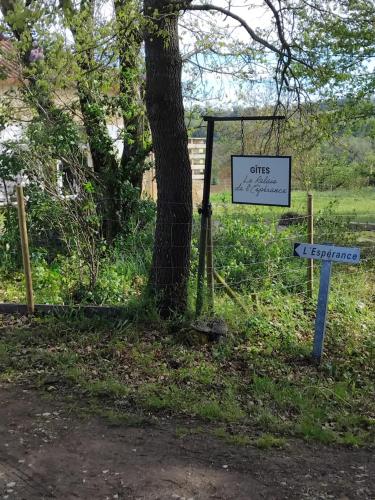 a tree with two street signs next to a tree at gite la bergerie in Larressingle
