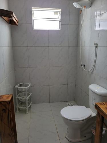 a bathroom with a toilet and a window at Casa Aconchego-Juazeiro do Norte CE Sao Jose in Juazeiro do Norte