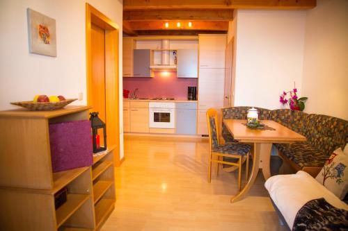 a living room and kitchen with a table and a couch at Gastreinhof in Meltina