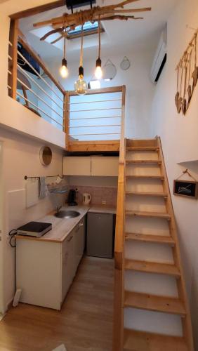 une cuisine avec un escalier menant à un loft dans l'établissement Studio cosy climatisé, à Amboise