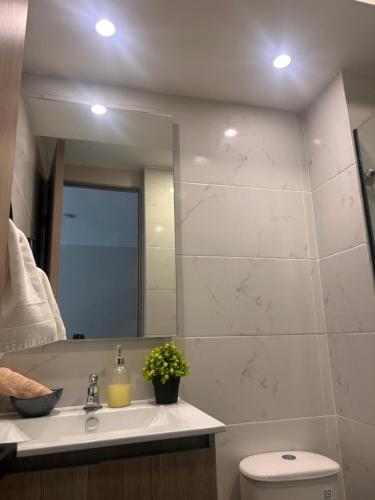 a bathroom with a sink and a mirror and a toilet at Nuevo apartamento de diseño para entrenar in Barranquilla