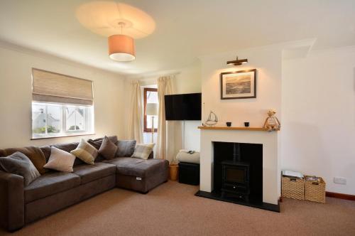 a living room with a couch and a fireplace at Family friendly house 200 meters to beach in Broad Haven