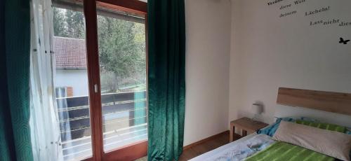 a bedroom with a bed and a large window at Haus Sieben - Singer Lydia in Kötschach