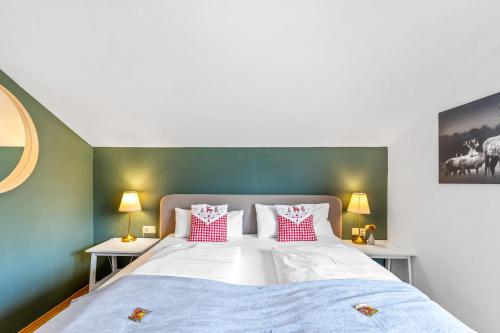 a bedroom with a bed with red and white pillows at CASARINA - Alpenblick am Barmsee - FeWo Viola in Krün