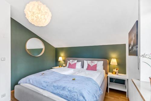 a bedroom with a large bed and a green wall at CASARINA - Alpenblick am Barmsee - FeWo Viola in Krün
