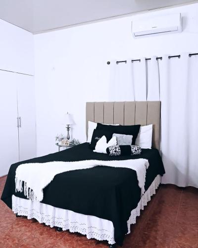 a bedroom with a large black and white bed at Casa de Wen in Santa Rita