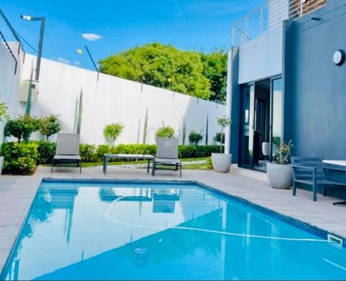 a swimming pool in front of a house at Stunning 1 bed in Midrand at 93 On New Estate in Midrand
