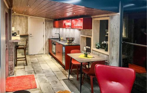 a kitchen with red cabinets and a table and chairs at Gorgeous Home In Vanse With Sauna in Vanse