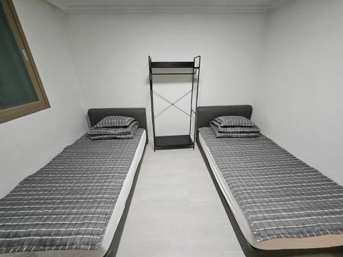 two beds sitting in a room with a mirror at Stay JAYU in Daejeon