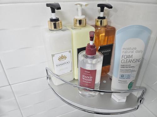 a shelf with four bottles of soap and alcohol at Stay JAYU in Daejeon