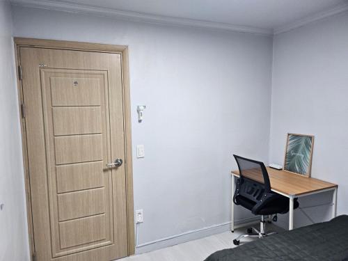 a bedroom with a door and a desk with a computer at Stay JAYU in Daejeon