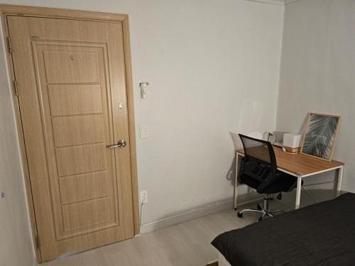 a bedroom with a door and a desk with a computer at Stay JAYU in Daejeon