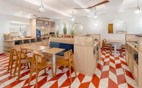 a kitchen with tables and chairs in a kitchen at Best Western Plus Au Grand Saint Jean in Beaune