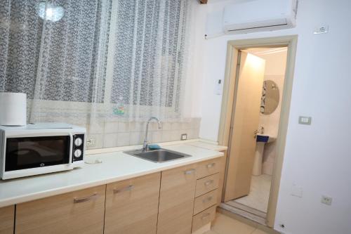una cucina con forno a microonde e lavandino di Mirage appartment a Tirana