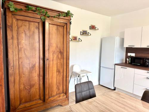 a kitchen with a wooden door and a refrigerator at Maison 6 personnes à 2 pas du Canal de Nantes à Brest in Carhaix-Plouguer