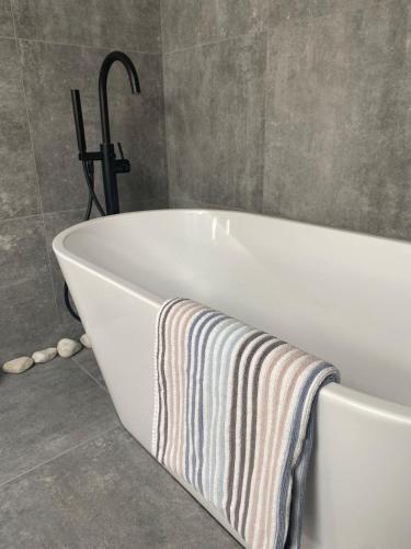 a bath tub with a striped towel on it in a bathroom at 160m piękny stylowy dwupoziomowy dom in Gdynia