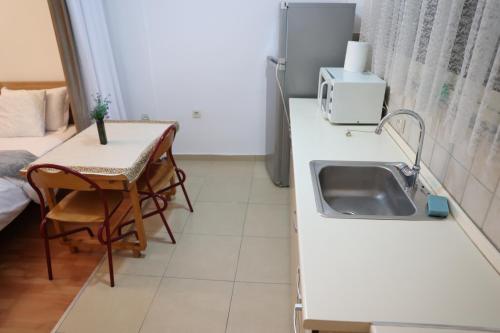 una cucina bianca con un lavello e un tavolo di Mirage appartment a Tirana