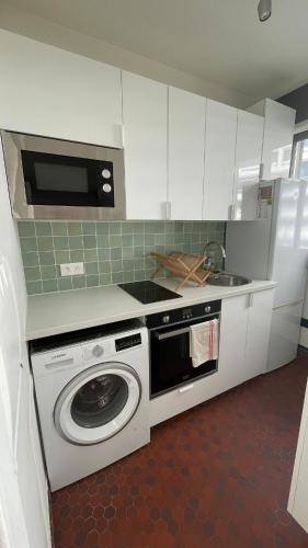 une cuisine avec un lave-linge et un micro-ondes dans l'établissement Grand studio fonctionnel, calme et ensoleillé, à Paris