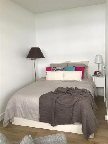 une chambre avec un lit avec une couverture grise dans l'établissement Grand studio fonctionnel, calme et ensoleillé, à Paris