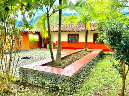 a house with a stone wall in front of it at Cabaña ideal 5-9 personas cocina, wifi, cerca al parque y campestre in Jardin